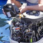 Man pouring and refueling engine motor oil into the engine for boat or yacht.