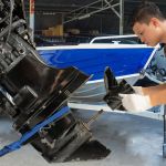 Repairing engines on aluminum boats , The technician is removing the boat parts to make the paint